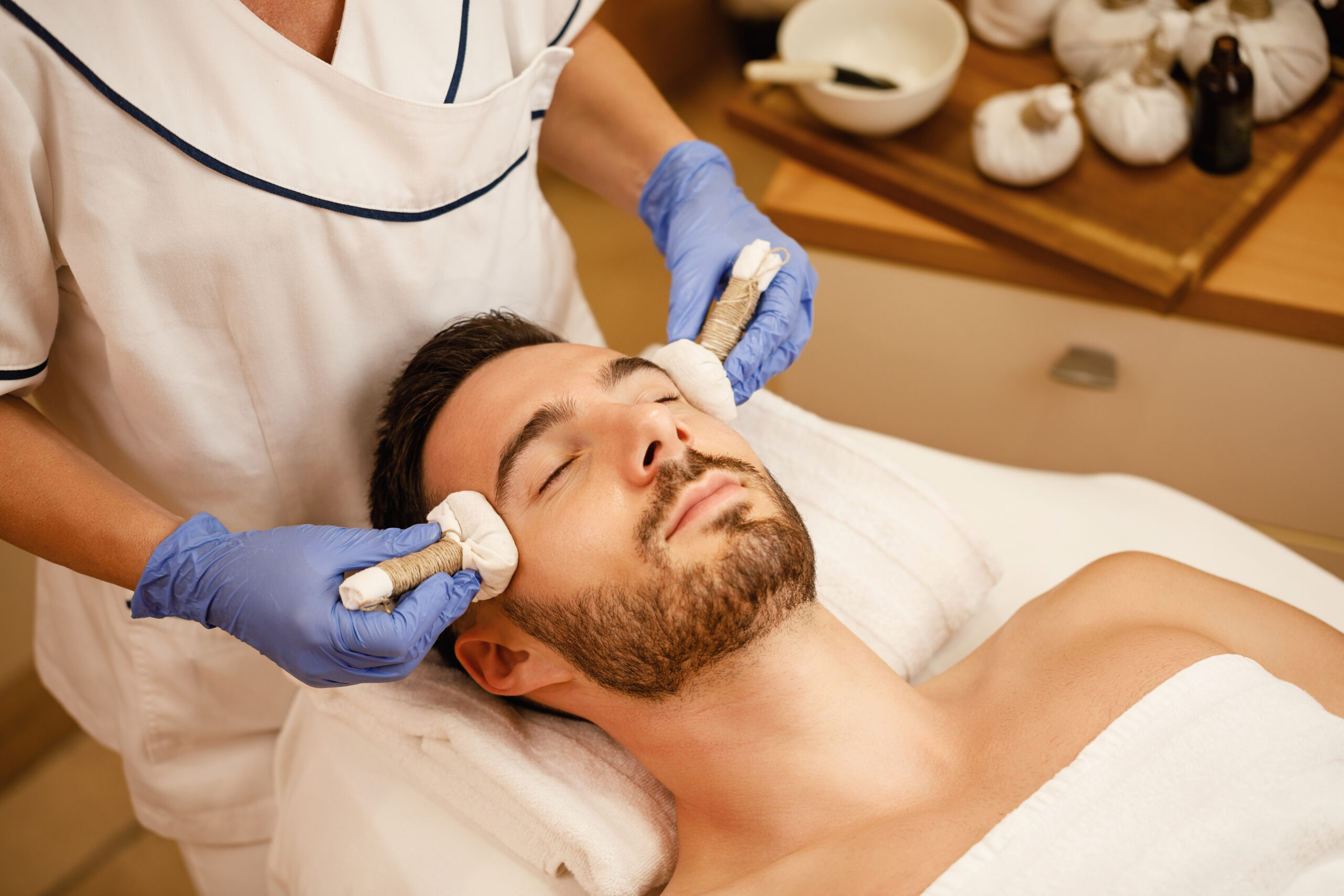 Relaxed man having facial  at wellness center be-pretty