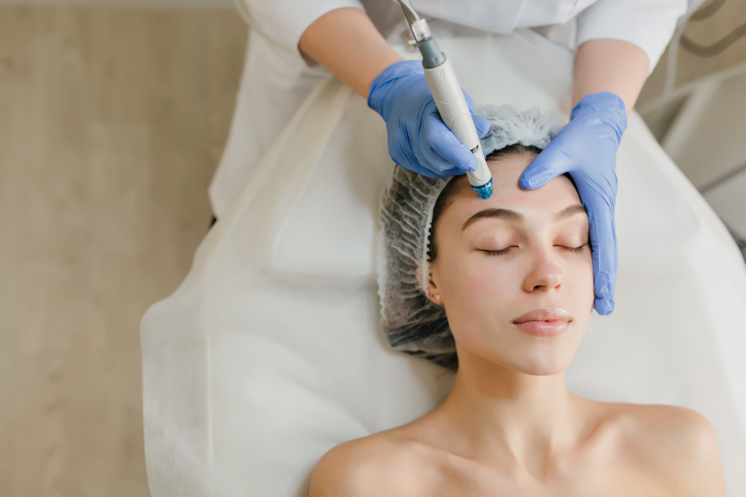 Woman in cosmetology studio having a micro- needling treatment