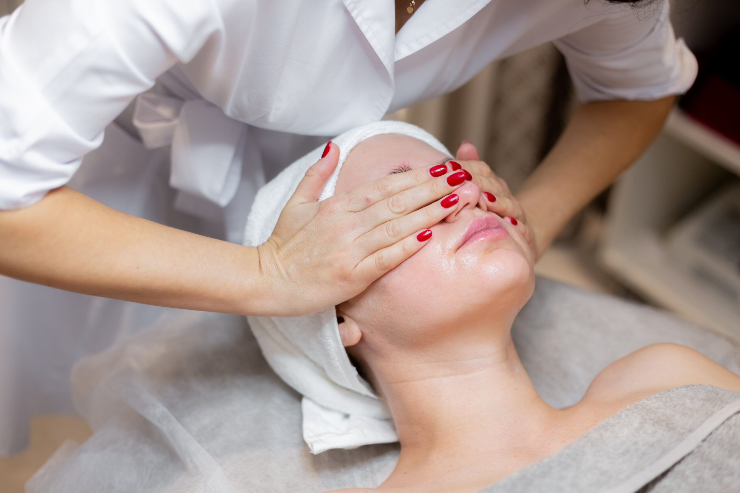 A young beautiful girl lies on the beautician's table and receives vampire facial with mesotherapy