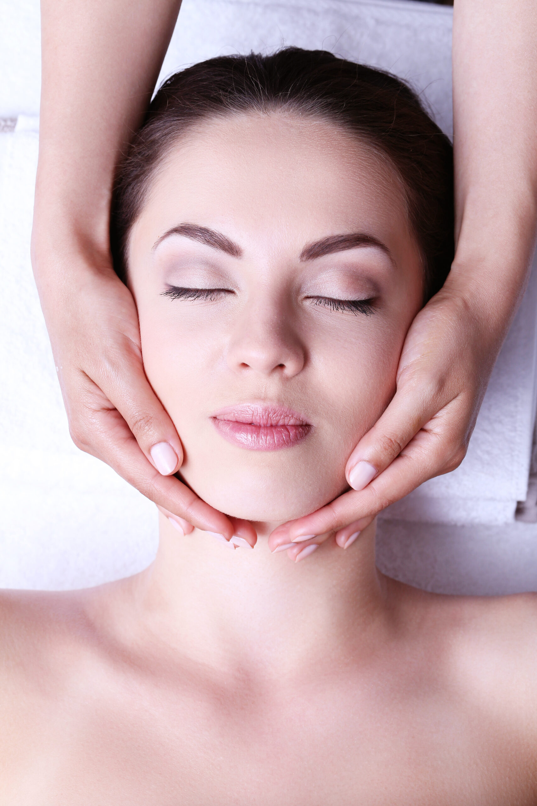 young woman having face massage scaled